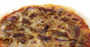 Kuva pulled porkilla, punasipulilla ja bbq-kastikkeella täytetystä pizzasta